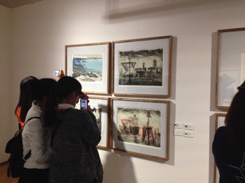 Students looking at prints by Ian Phillips and Jimmy Pasakos
